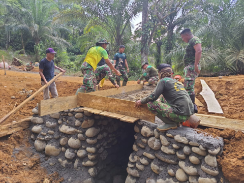 Satgas TMMD ke-114 Kodim 0423/BU Mengaduk Semen Untuk Pengecoran Gorong-Gorong